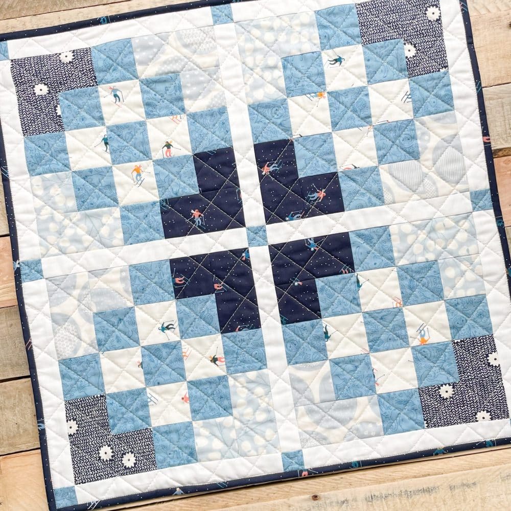 Handcrafted blue and white quilt from Heart Lake Quilts featuring intricate patchwork and unique design patterns.