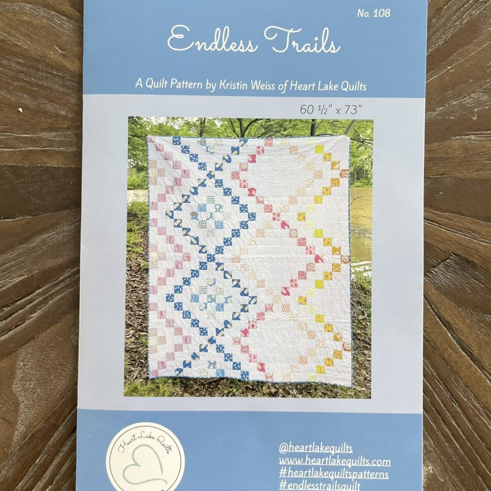 Cover of Endless Trails quilt pattern by Heart Lake Quilts on a wooden background, with colorful geometric quilt design.