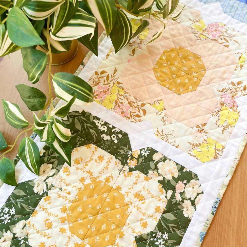 Floral quilt pattern by Heart Lake Quilts with green leaves. Quilt design and leaf decor inspiration.