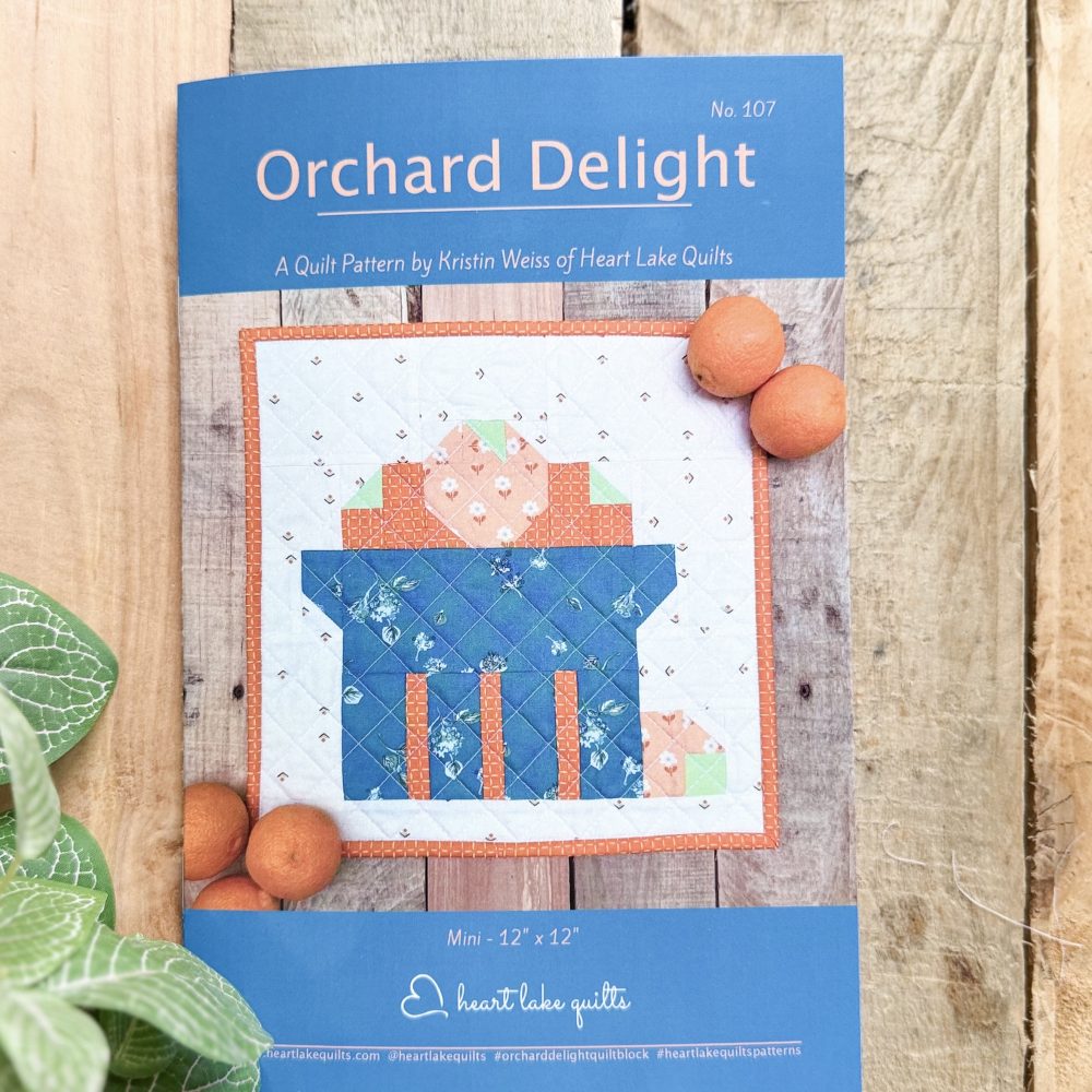 Orchard Delight quilt pattern cover with oranges